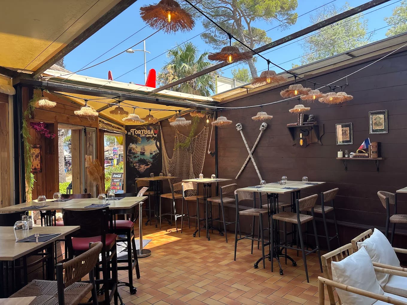 La terrasse pirate du Tortuga : filets, crânes et suspensions en paille face à la mer